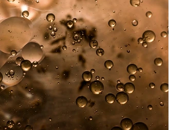 Brown liquid with oil-like bubbles of varying sizes