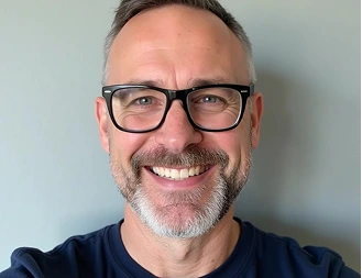 David Wing, smiling man with gray beard and black-framed glasses