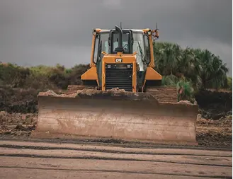 Yellow bulldozer with blade on a dirt work site