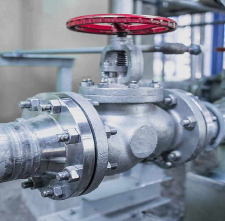Flanged bolted gate valve with red handwheel on an industrial pipeline