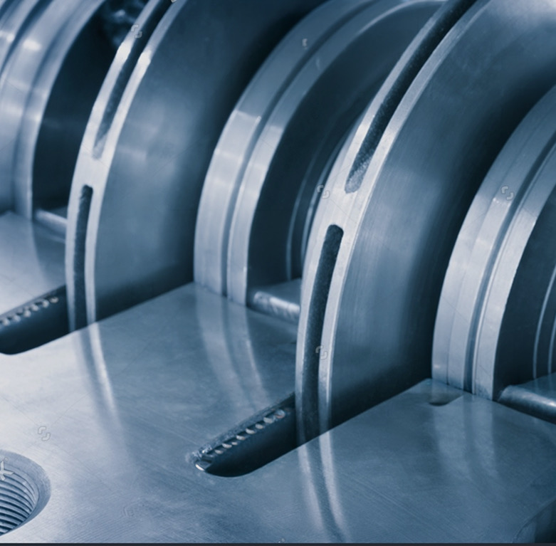 Close-up of machined steel wear rings and slotted discs with blue-toned lighting